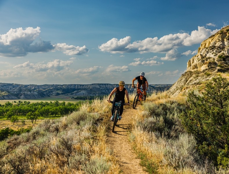 Two people riding mountain bikes on a trail.