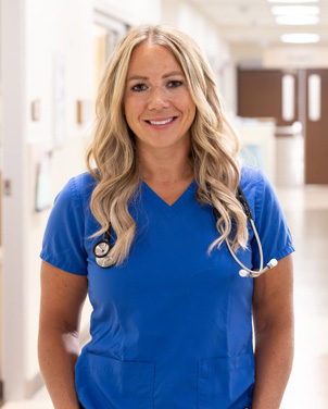 Female nurse standing in the hallway.